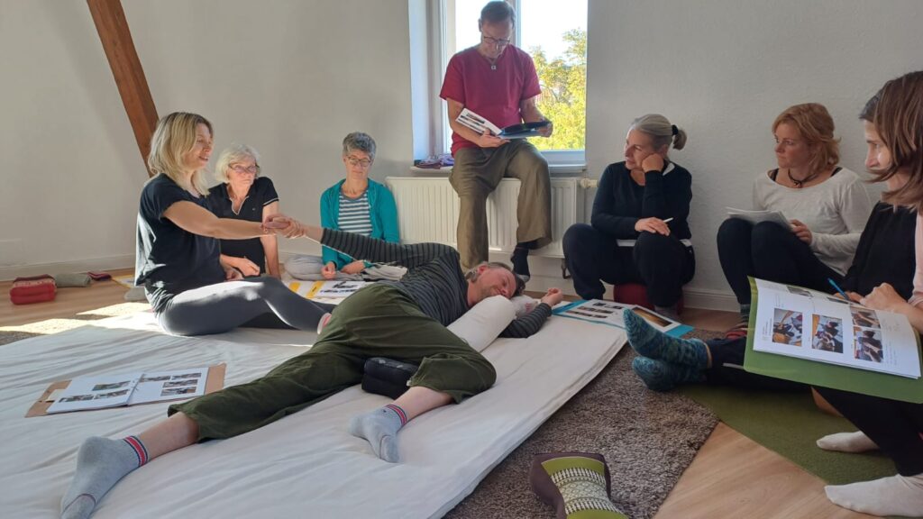 Workshop‑Szene / Körperarbeit Teilnehmer:innen in einem Körperarbeits‑Workshop im YOU & THAI Studio, ruhige Lernatmosphäre mit Demonstration und Beobachtung.